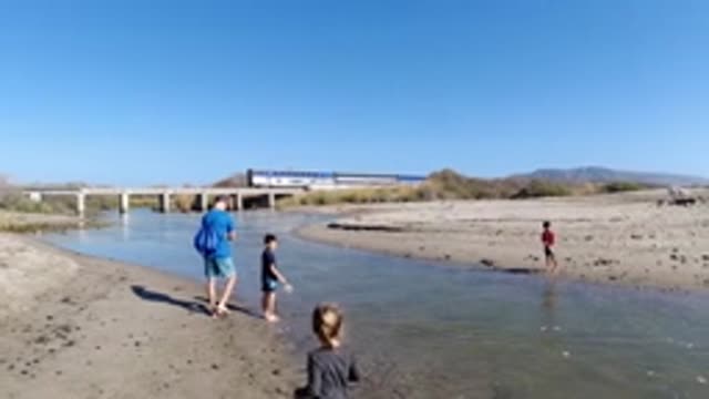 TRESTLES BEACH CALIFORNIA-2019: Children Play at River, Sandbar, and Beach Near Train