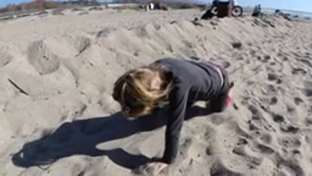 TRESTLES BEACH CALIFORNIA-2019: A Child Plays Showing A Parody Of A Dog On The Beach