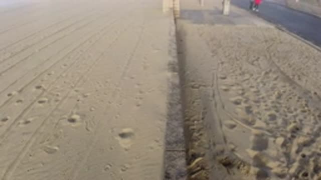 HUNTINGTON BEACH CALIFORNIA-2019: Two People Walking On The Street Beside The Beach