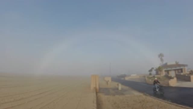 HUNTINGTON BEACH CALIFORNIA-2019: Couple Running And Riding Bicycle In Rain With Rainbow