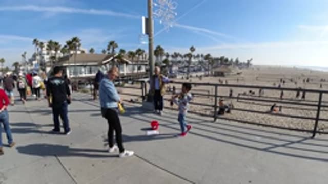 HUNTINGTON BEACH CALIFORNIA-2019: People Walking On A Concrete Road Next To A