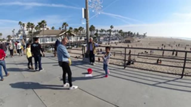 HUNTINGTON BEACH CALIFORNIA-2019: A Man Watching A Boy Perform The Violin On