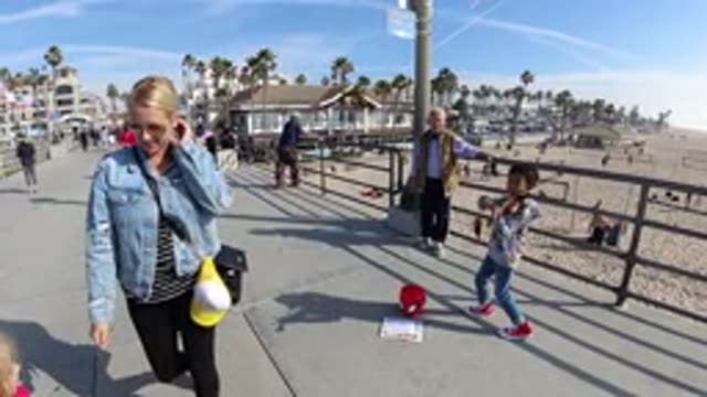 HUNTINGTON BEACH CALIFORNIA-2019: Mom And Daughter Walking On The Beach With