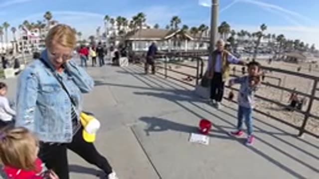 HUNTINGTON BEACH CALIFORNIA-2019: On A Sandy Beach A Child Plays The Violin As A Mother Watches