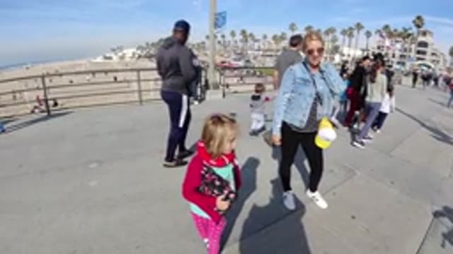 HUNTINGTON BEACH CALIFORNIA-2019: People Walking Around In A City With A Kid In Red Jacket