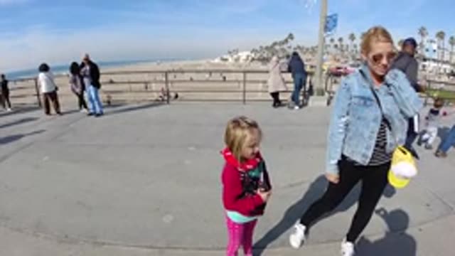 HUNTINGTON BEACH CALIFORNIA-2019: Woman With Child Stop To Speak With Interviewer
