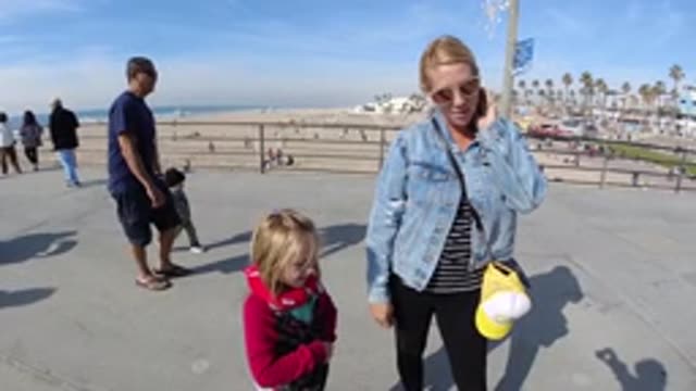HUNTINGTON BEACH CALIFORNIA-2019: Mother and Daughter Clapping Near Sea With Palms