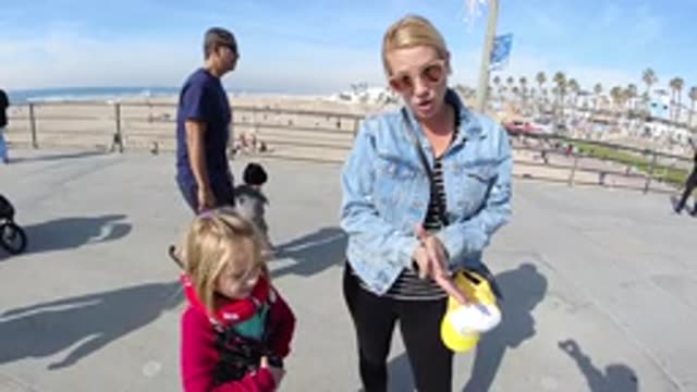 HUNTINGTON BEACH CALIFORNIA-2019: A Woman Clapping Beside A Little Girl And A Toddler