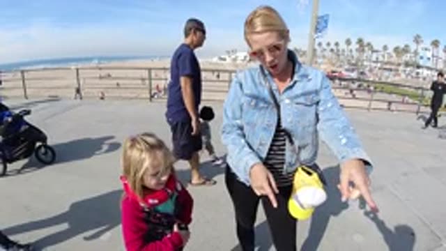 HUNTINGTON BEACH CALIFORNIA-2019: A Mother Points Afar Beside Her Cute Toddler