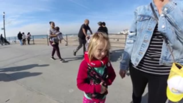 HUNTINGTON BEACH CALIFORNIA-2019: A Blonde Child Smiling in Slow Motion on a Bridge