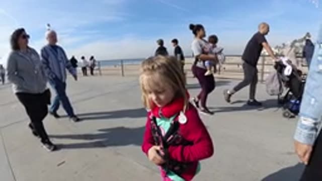 HUNTINGTON BEACH CALIFORNIA-2019: Young Girl In Red Walking On The Sidewalk Near Beach