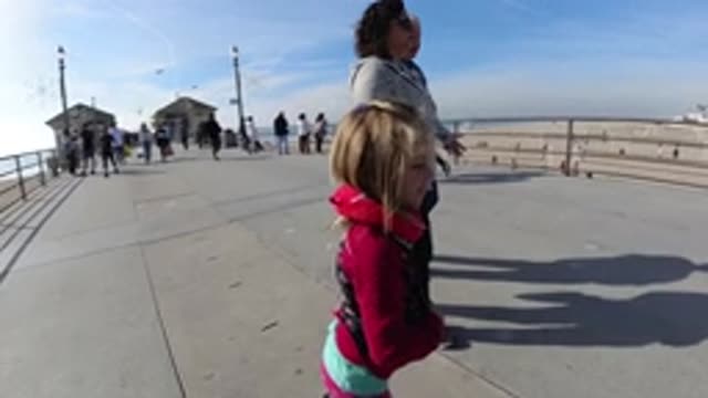 HUNTINGTON BEACH CALIFORNIA-2019: Young Girl And Woman Walk On Boardwalk With