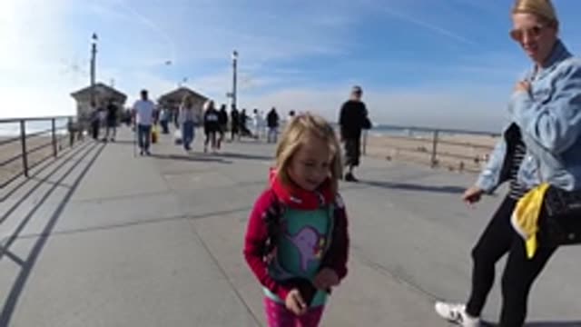 HUNTINGTON BEACH CALIFORNIA-2019: Blonde Girl With Her Mom Walking Along the Pier