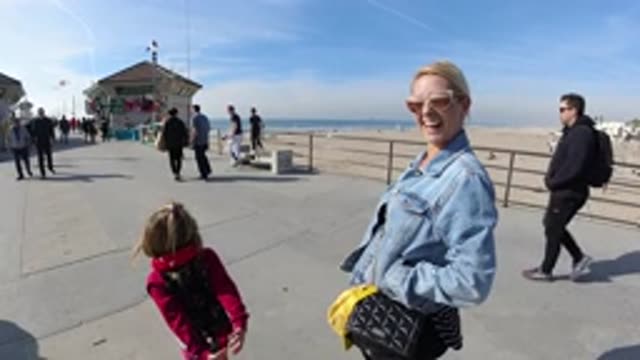HUNTINGTON BEACH CALIFORNIA-2019: Little Cute Girl In Red Jacket Taking A Walk