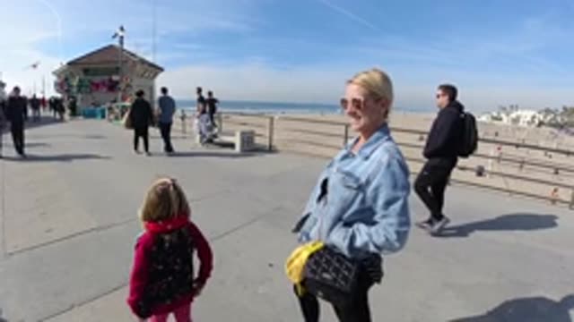 HUNTINGTON BEACH CALIFORNIA-2019: Woman And Child Walking On The Boardwalk At