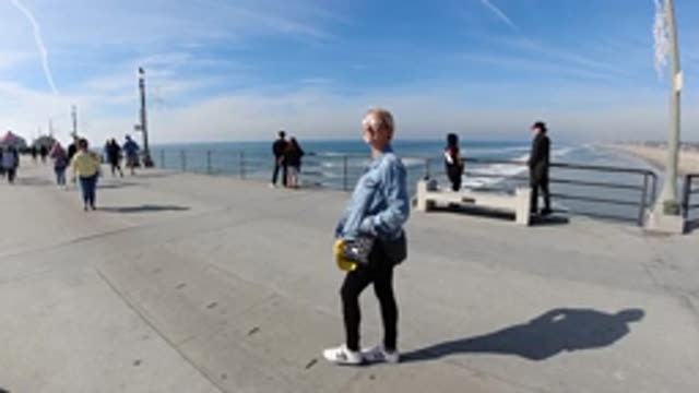 HUNTINGTON BEACH CALIFORNIA-2019: Slow Motion Woman Walking On A Pier By The Ocean