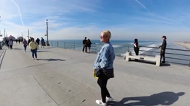 HUNTINGTON BEACH CALIFORNIA-2019: Slow Motion Woman Walking Down Pier At Beach