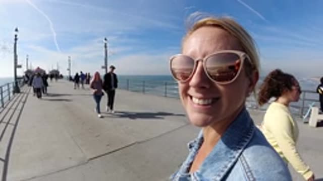 HUNTINGTON BEACH CALIFORNIA-2019: Happy Woman Vacation Ocean Walking Pier Crowds