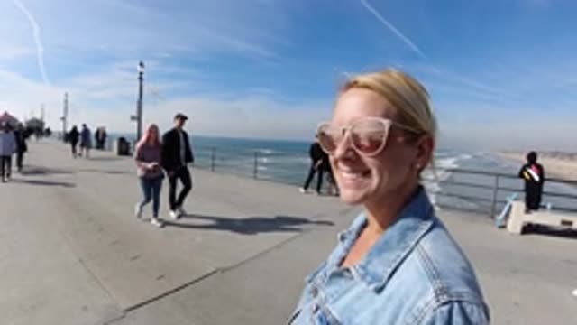 HUNTINGTON BEACH CALIFORNIA-2019: A Woman Smiling With Sunglasses On A Dock Over