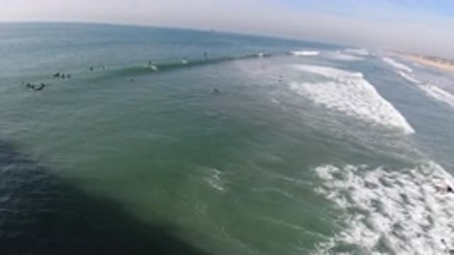 HUNTINGTON BEACH CALIFORNIA-2019: A Group Of People Surfing On A Beach In
