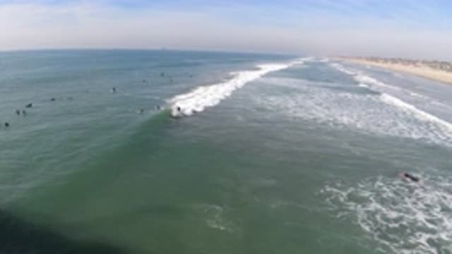 HUNTINGTON BEACH CALIFORNIA-2019: Surfer Drops In On Wave At Surf Spot And Rides