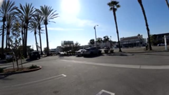 HUNTINGTON BEACH CALIFORNIA-2019: Traffic Passes By On City Street With Palm Trees