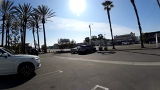 HUNTINGTON BEACH CALIFORNIA-2019: Cars Driving By On A City Street With Sun In