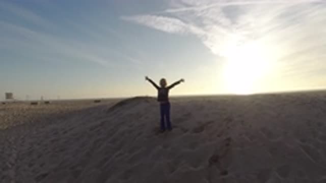 BOLSA CHICA CALIFORNIA-2019: A Person With Arms Stretched At Sunset On The Beach