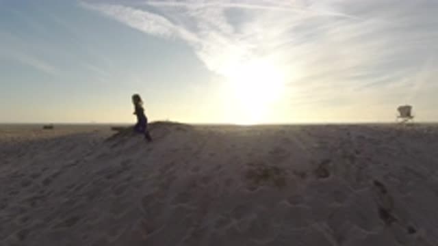 BOLSA CHICA CALIFORNIA-2019: Child Runs Across The Sand Toward A Road With The
