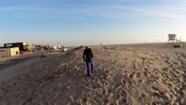 BOLSA CHICA CALIFORNIA-2019: A Young Girl And Her Dog Walking Up A Sand Dune At
