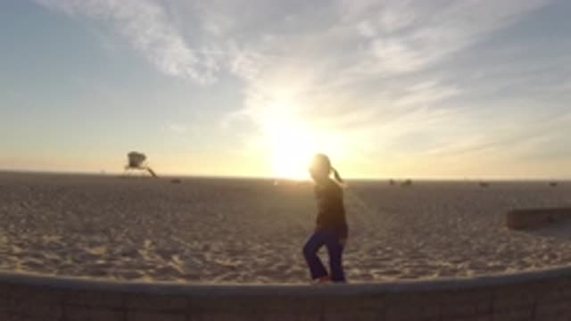 BOLSA CHICA CALIFORNIA-2019: A Barefoot Little Ponytail Girl At Sunset Walks On