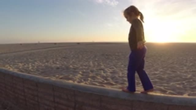BOLSA CHICA CALIFORNIA-2019: A Little Girl Balancing On The Beach Promenade