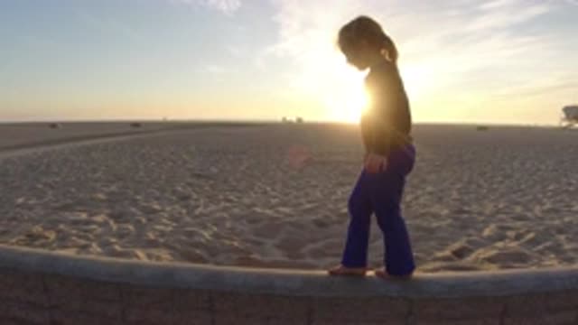 BOLSA CHICA CALIFORNIA-2019: Young Girl Walking On The Beach Enjoying The Sunset