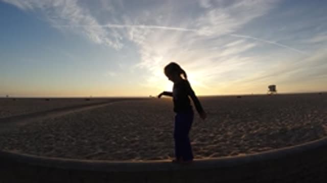 BOLSA CHICA CALIFORNIA-2019: Slow Motion Child Practicing Balancing Skills At A Beach