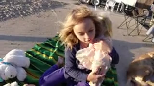 BOLSA CHICA CALIFORNIA-2019: Little Girl Plays With Her Doll While Sitting On A