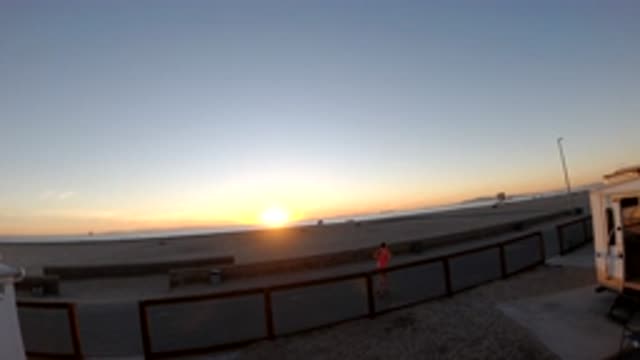 BOLSA CHICA CALIFORNIA-2019: Sun On Horizon Line Film Seeded Up People Jog And Ride Bikes