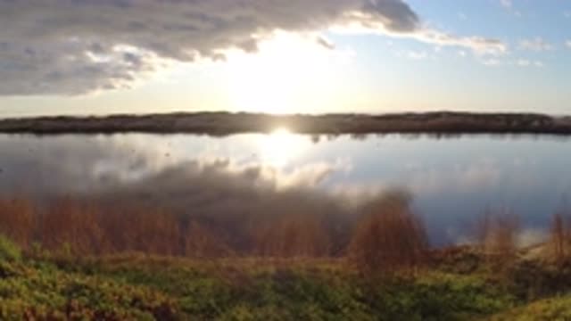 PISMO BEACH CALIFORNIA-2019: Adorable Sun Setting Over a Lake from the Lake Bank