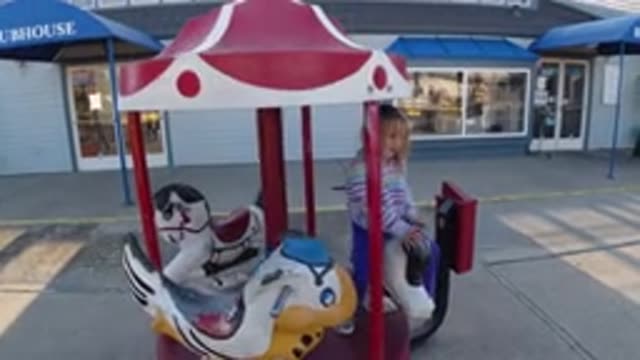 PISMO BEACH CALIFORNIA-2019: A Girl Plays On The Carousel