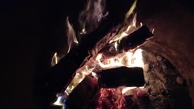 PISMO BEACH CALIFORNIA-2019: Three Logs In Fire Pit With Embers And Flames