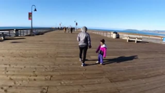 PISMO BEACH CALIFORNIA-2019: Mom And Daughter Walking On A Pier Going Out To The