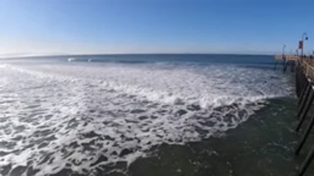 PISMO BEACH CALIFORNIA-2019: Person Standing On Bridge Over Ocean Waves