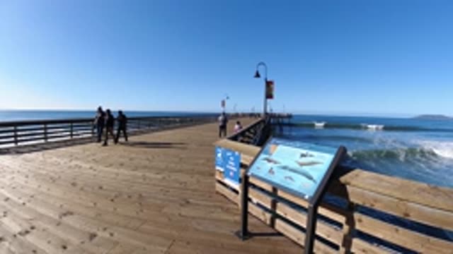 PISMO BEACH CALIFORNIA-2019: Friends Shadow Walking Behind On Seashore Bridge