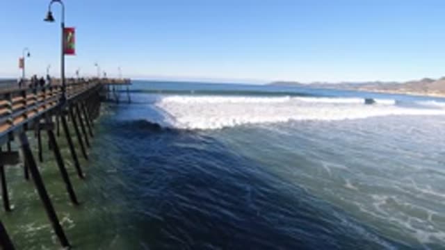 PISMO BEACH CALIFORNIA-2019: Wooden Pier With People On The Left Ocean Waves On