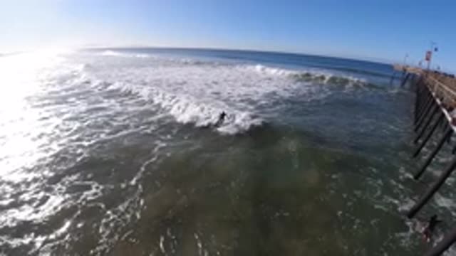 PISMO BEACH CALIFORNIA-2019: Catching A Wave On A Sunny Blue Sky Day In Slow Motion
