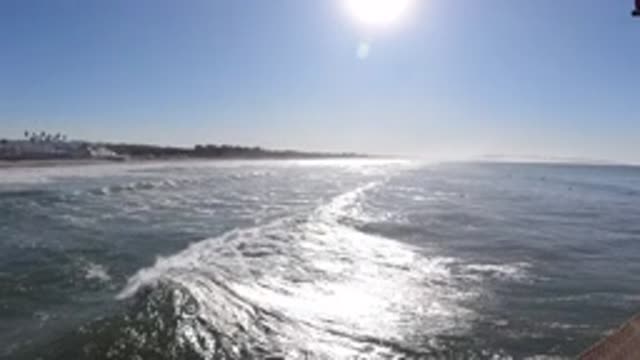PISMO BEACH CALIFORNIA-2019: Wave Rolling In Towards Shore From Pier Over Water