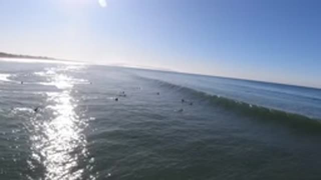 PISMO BEACH CALIFORNIA-2019: A Wave On The Ocean Starts To Break And Surfers Try