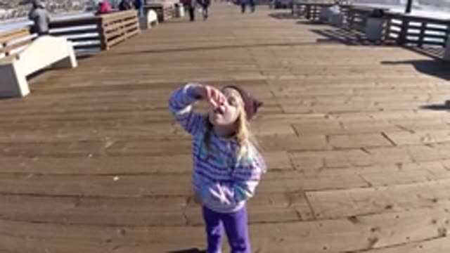 PISMO BEACH CALIFORNIA-2019: Girl Wearing Brown Hat Eating On A Sunny Day