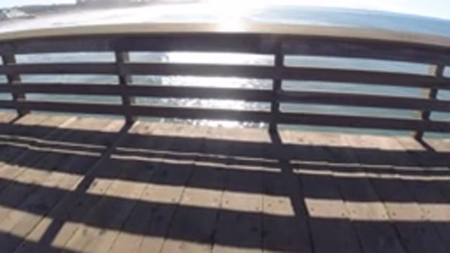 PISMO BEACH CALIFORNIA-2019: Slowly Walking Over A Bridge With A Large Body Of Water