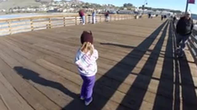 PISMO BEACH CALIFORNIA-2019: A Little Girl Wearing Warm Clothes And Purple Hat