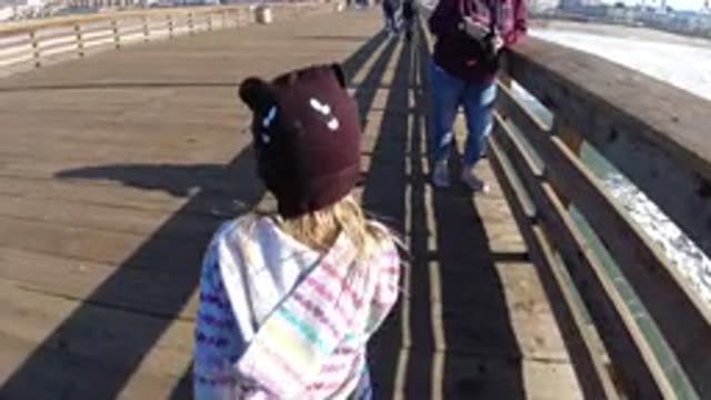 PISMO BEACH CALIFORNIA-2019: A Little Girl Skipping On A Dock Outside During